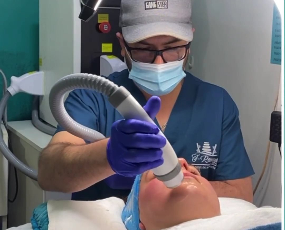 Profesional de Clínica T-Renova SPA con uniforme quirúrgico turquesa aplicando aparatología facial